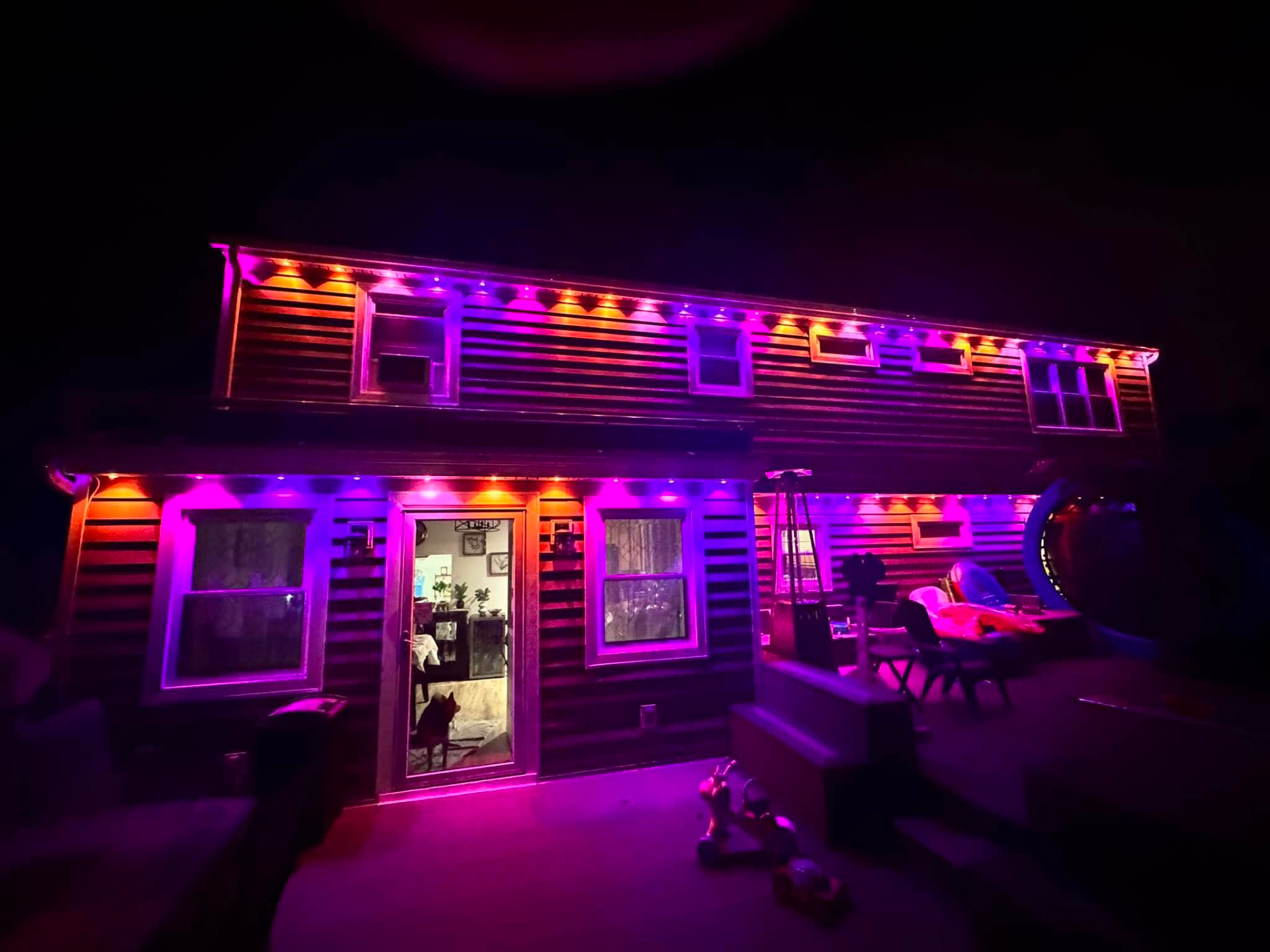Color-changing roofline lighting across the back of a home