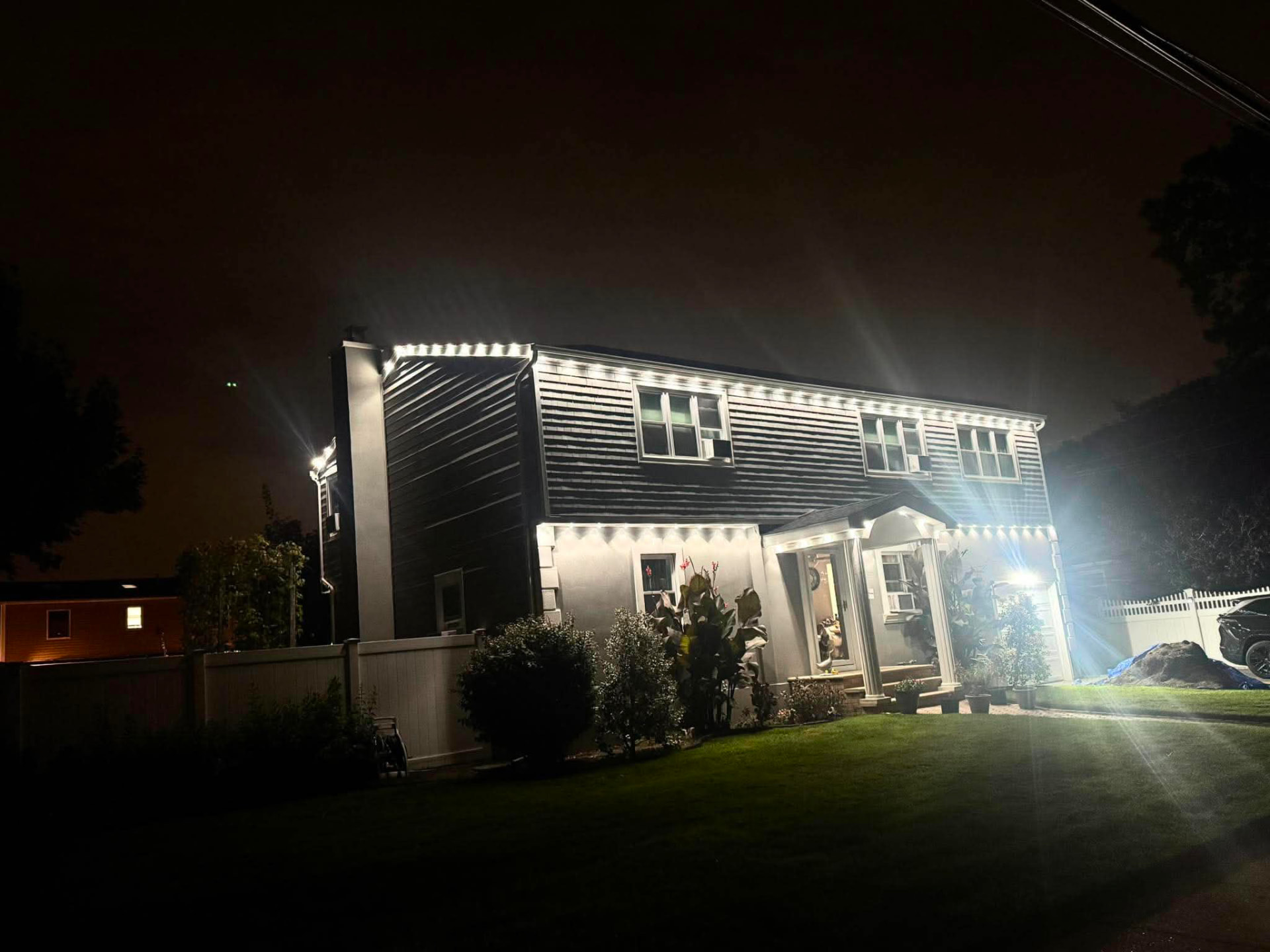 Warm white roofline lighting on a two-story home